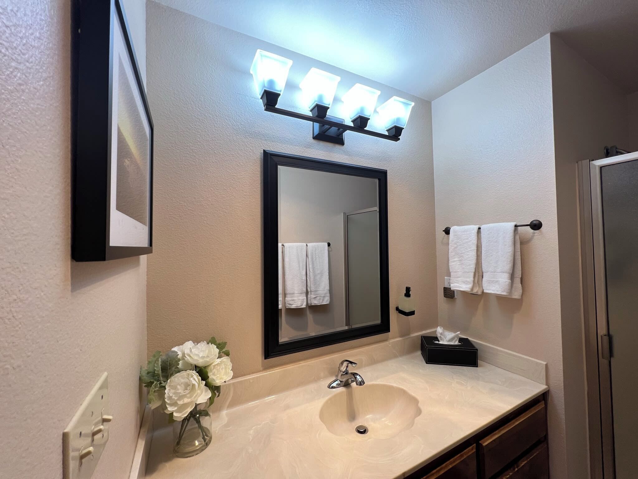 A bathroom with a sink, mirror, and towel rack.