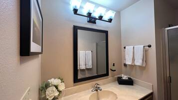 A bathroom with a sink, mirror, and towel rack.