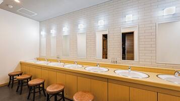 A long, single sink vanity with multiple mirrors and stools.