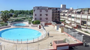 Ein Hotel mit Poolbereich auf dem Dach, mehreren Balkonen und Blick auf die umliegende Landschaft.