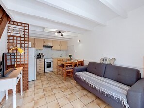 Una cocina moderna con comedor, sofá y mesa de madera.