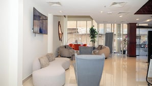 A modern lobby with a seating area, a large window, and a plant. - CITY POINT HOTEL (Manama)