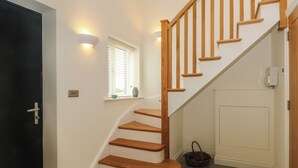 A staircase with wooden steps and a handrail, leading to a landing with a white door. - Kestrel (Malpas)