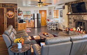 A living room with leather sofas, a coffee table, and a fireplace. -  10 minutes to hiking, fishing, Dining and Shopping-Lonesome Pine Cabin (Lakeside)