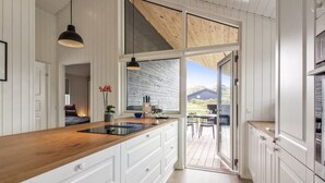 A modern kitchen with a wooden countertop, white cabinetry, and a large window. - "Alea" - 800m from the sea by Interhome (Hjørring)