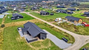 An aerial view of a residential area with modern houses, a central paved path, and a body of water in the background. - "Alea" - 800m from the sea by Interhome (Hjørring)