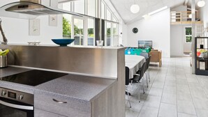 Una cocina moderna con una isla grande, electrodomésticos de acero inoxidable y vistas al exterior.
