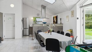 Una cocina moderna con comedor, una mesa grande y una mesa de futbolín.