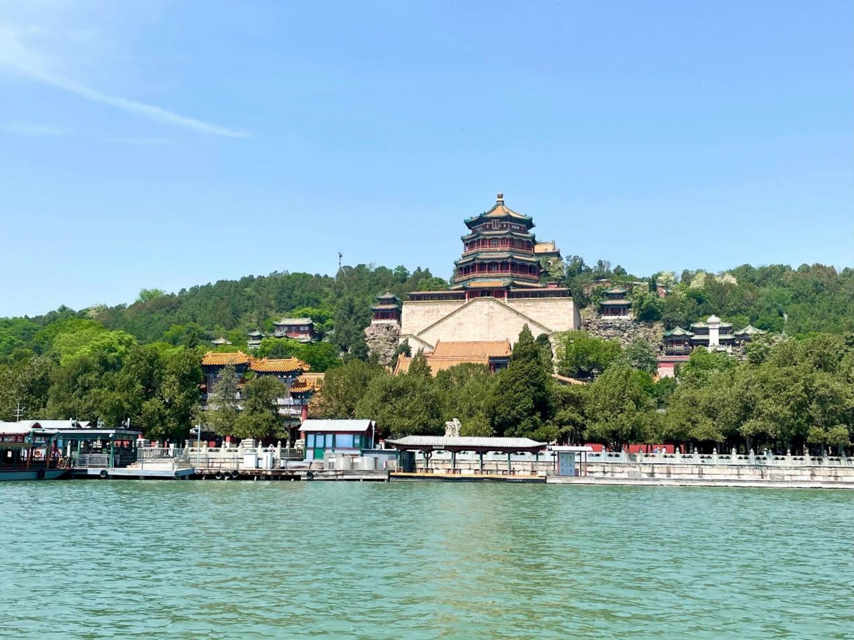 A traditional Chinese pagoda with multiple tiers, surrounded by lush greenery and a body of water in the foreground.
