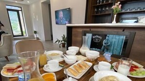 Un bufé de desayuno con diversos platos, entre ellos huevos, bollería y fruta.
