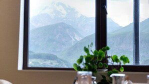 Una mesa con vista a las montañas a través de una ventana.