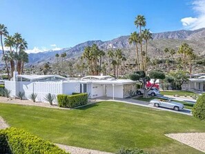 Une maison moderne avec un garage, une allée et une voiture garée devant.