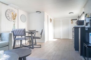 Enjoy meals in this kitchen with a dining table and chairs, a refrigerator, microwave, and coffee maker.
