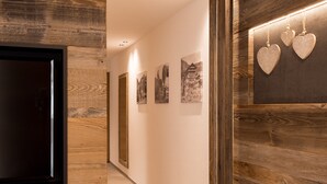 Ein Korridor mit Holzvertäfelung, einer geframten Tür und Wandbildern.