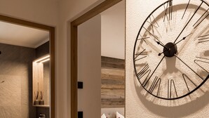 Ein modernes Badezimmer mit Waschtisch, einer großen Wanduhr und Holzboden.