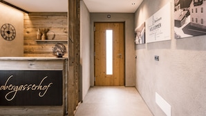 A reception area with a wooden reception desk, a wall clock, and a framed welcome sign.