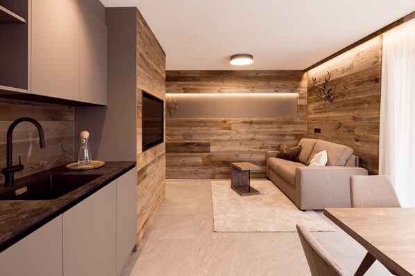A modern kitchen with a dark countertop, a built-in oven, and a sink.