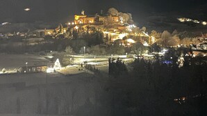 A nighttime view of a historic building with illuminated windows and a prominent tower, surrounded by a hilly landscape. - Holiday Home 'Casa Pifaro' in Monterchi (Monterchi)