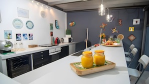 Een moderne keuken met een centraal eiland, een magnetron, een waterkoker en diverse wanddecoraties.