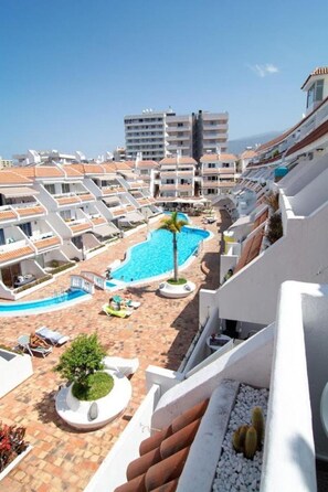A resort with a swimming pool, lounge chairs, and a view of the sea. - Holiday Home 'Le Petit Paradise' with Shared Pool, Terrace & Wi-Fi (Adeje)