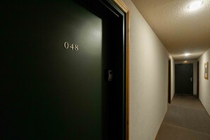 A hallway with a door marked '048' and a light fixture on the ceiling. - Holiday Apartment "Valfréjus" in Valfréjus (Modane)