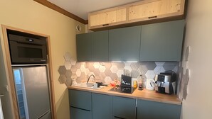 Eine kleine Küche mit Mikrowelle, Spüle und Kaffeemaschine.
