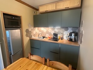 A compact kitchen with a microwave, sink, and coffee maker. - Holiday Apartment "Valfréjus" in Valfréjus (Modane)