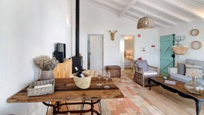 Una sala de estar acogedora con una mesa de madera, cestas de mimbre, una chimenea y una puerta azul.