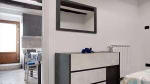 Un dormitorio con cama, cómoda, espejo y ventana.
