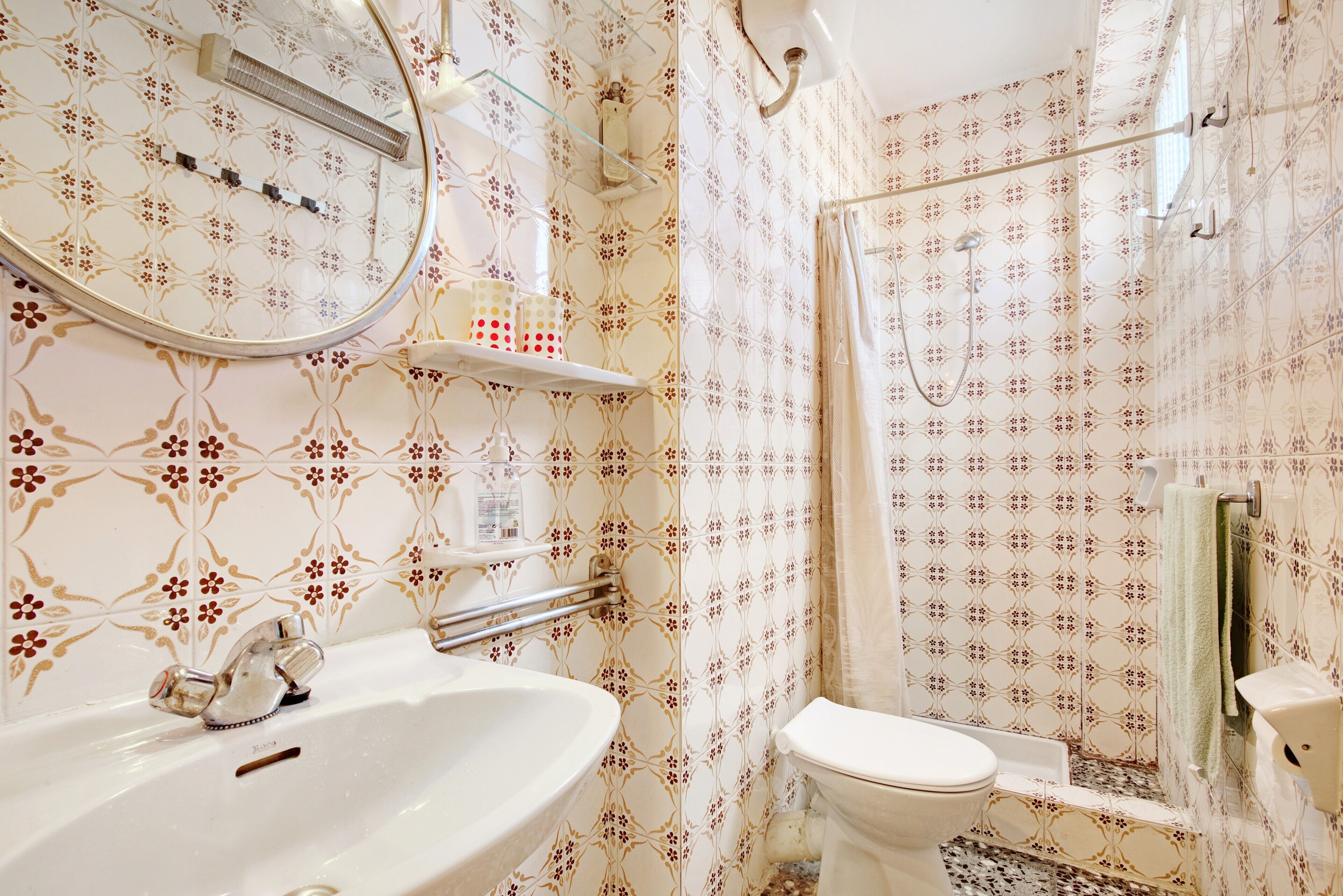 A bathroom with a sink, toilet, and shower area.