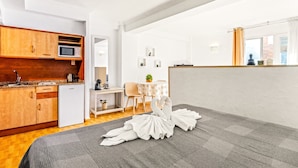 Un espacio habitable compacto con kitchenette, comedor y vistas a la ciudad.