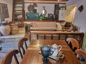 Uma mesa de jantar de madeira com cadeiras, um banco e uma preparação para café.