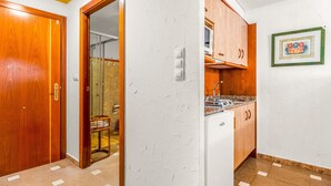 A kitchen with wooden cabinets, a white refrigerator, and a tiled backsplash.