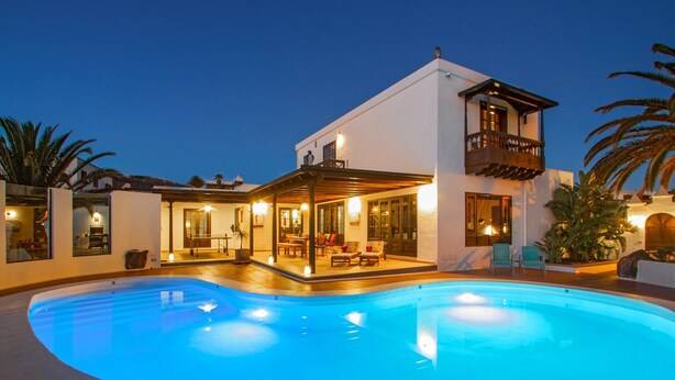 Una casa moderna con piscina, balcón y zona de patio.