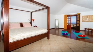 Una cama con dosel de madera, una mesita de noche y un atril.