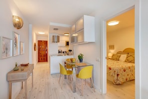 Un appartement moderne comprenant un coin repas, une cuisine et une chambre.