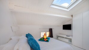 A bedroom with a bed, a TV, a skylight, and a window. - Holiday Apartment 'De luxe Bluesky' with Terrace, Balcony & Wi-Fi (Beausoleil)