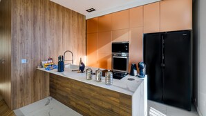 A modern kitchen with wooden cabinetry, a black refrigerator, and stainless steel appliances. - Holiday Apartment 'De luxe Bluesky' with Terrace, Balcony & Wi-Fi (Beausoleil)