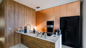 Una cucina moderna con mobili in legno, un frigorifero nero ed elettrodomestici in acciaio inossidabile.