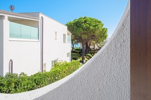 A modern building with large windows, a tree, and a white wall. - Holiday Apartment 'Blue House Laconia' with Sea View, Balcony & Air Conditioning (Canniggione)