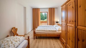 A bedroom with two beds, wooden wardrobe, and a window with curtains. - Apartment 'Bachwiesl Hof Wies' with Mountain View, Shared Terrace and Wi-Fi (Proves)