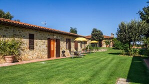 A stone building with a tiled roof, a well-maintained lawn, and outdoor seating. - Apartment 'Tartaruga' with Shared Pool, Wi-Fi and Air Conditioning (Montiano)