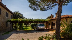 Un bâtiment en pierre avec une voiture garée devant.