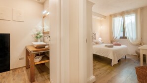 Ein Schlafzimmer mit Bett, Nachttisch und einem Fenster mit Vorhängen.