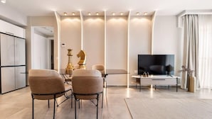 A modern living room with a sofa, coffee table, TV, and decorative items.