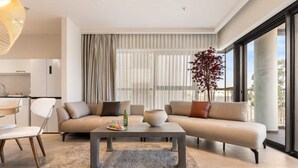 Un salon moderne avec un canapé, une table basse et un coin repas.