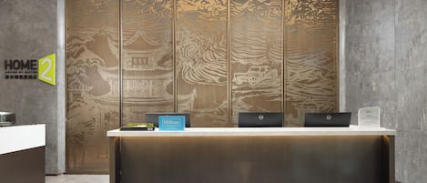 A reception desk with a modern design, a sign for 'Hilton Honors,' and a 'Reception' sign.