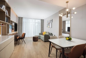 A modern living room with a dining area, a sofa, a coffee table, and a large mirror.