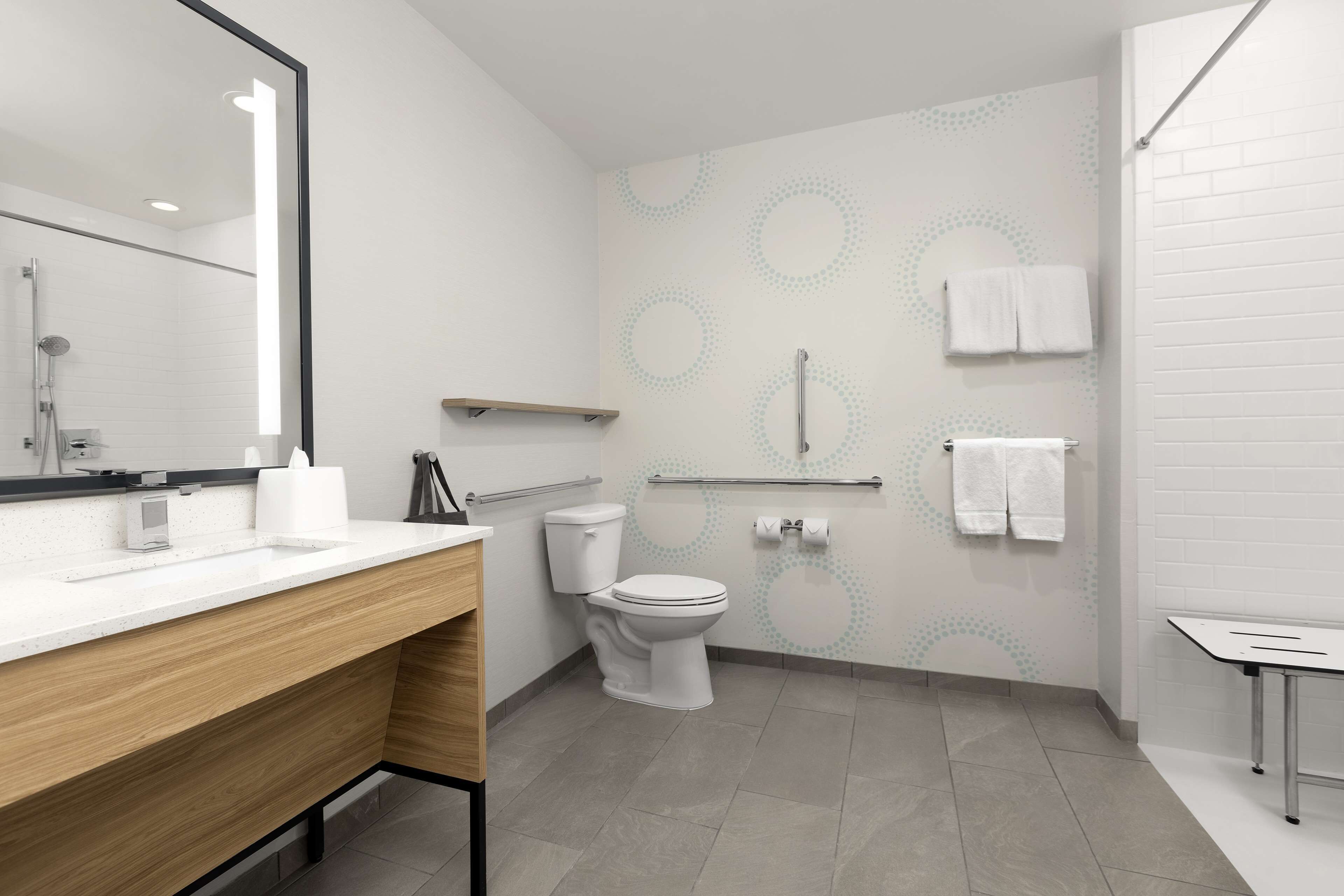 Une salle de bain moderne avec des toilettes, un lavabo et un miroir.