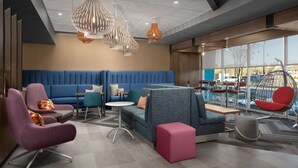 Un espacio lounge moderno con asientos, mesas y lámparas de diseño.